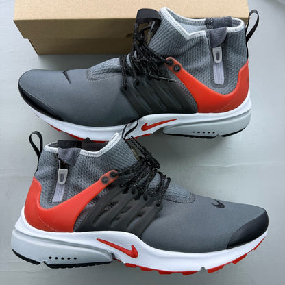 Nike Air Presto grey trainers with black and red accents, featuring a sleek design.