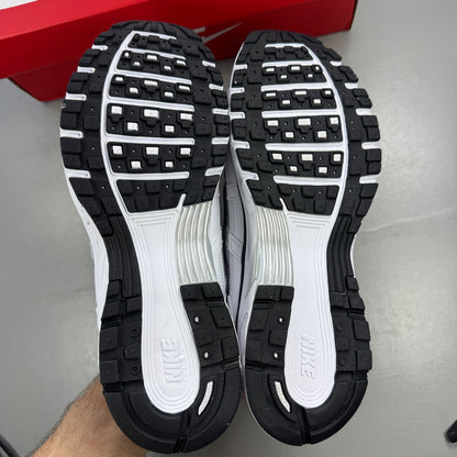Nike white trainers with metallic silver accents and black detailing, featuring a sleek design.