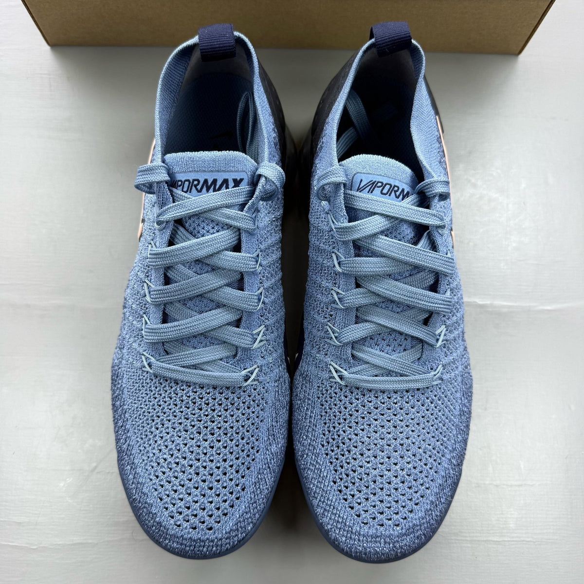 Nike blue trainers with Flyknit upper and Air cushioning technology.