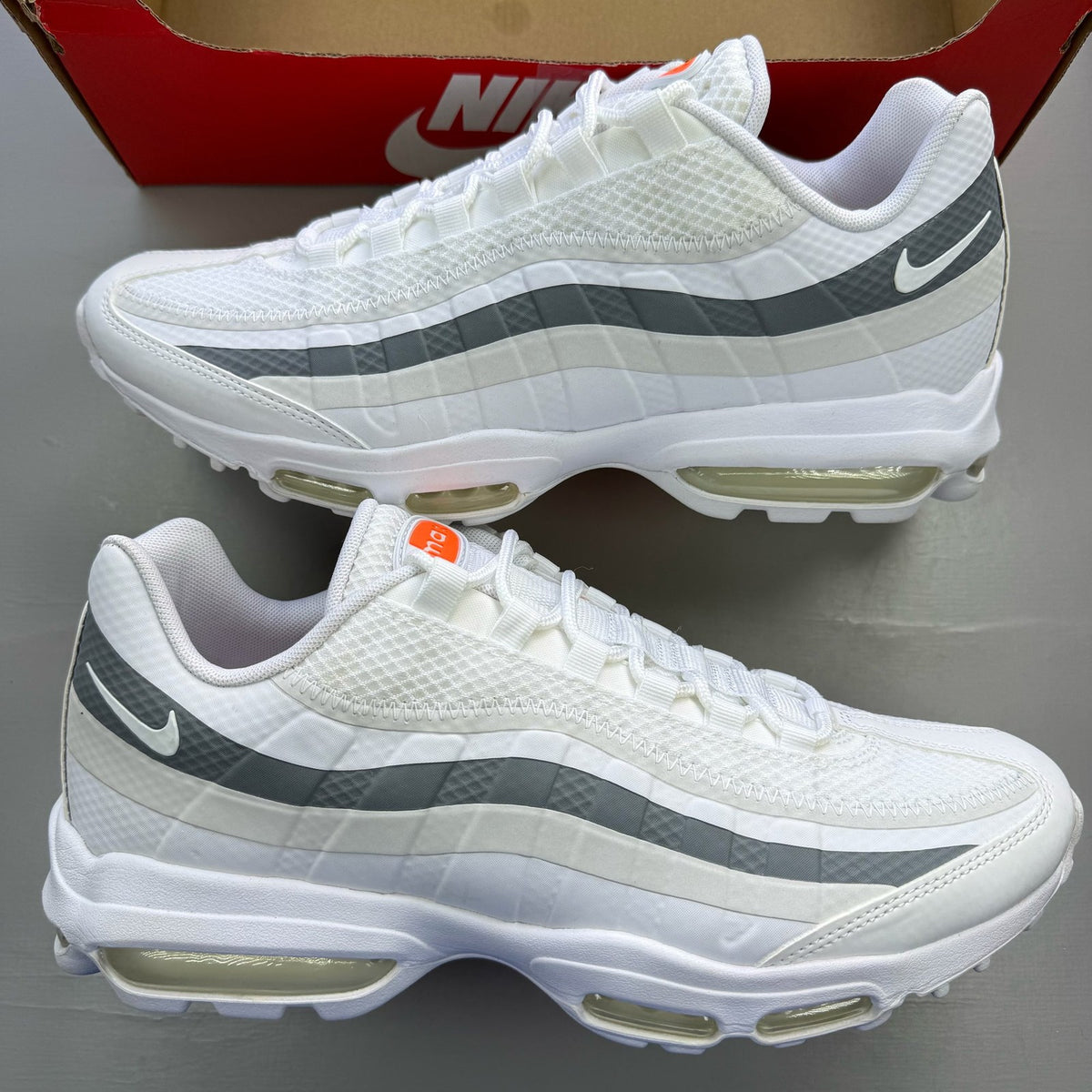 Nike Air Max 95 white trainers with grey accents and signature swoosh logo.
