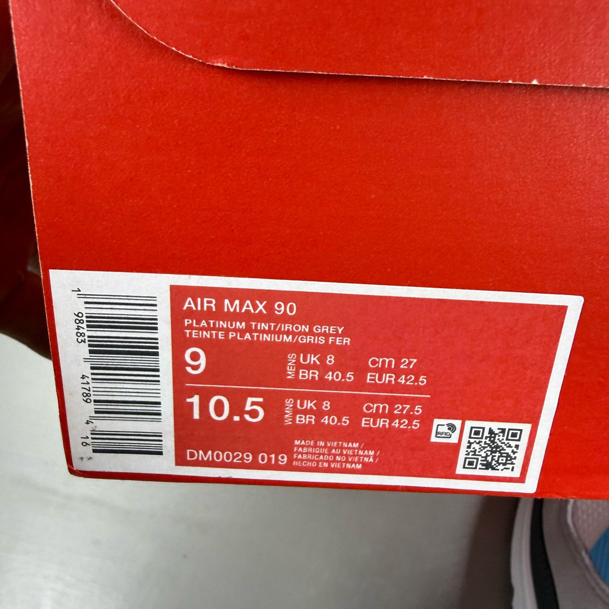 Nike Air Max 90 grey trainers with blue accents and signature swoosh logo.