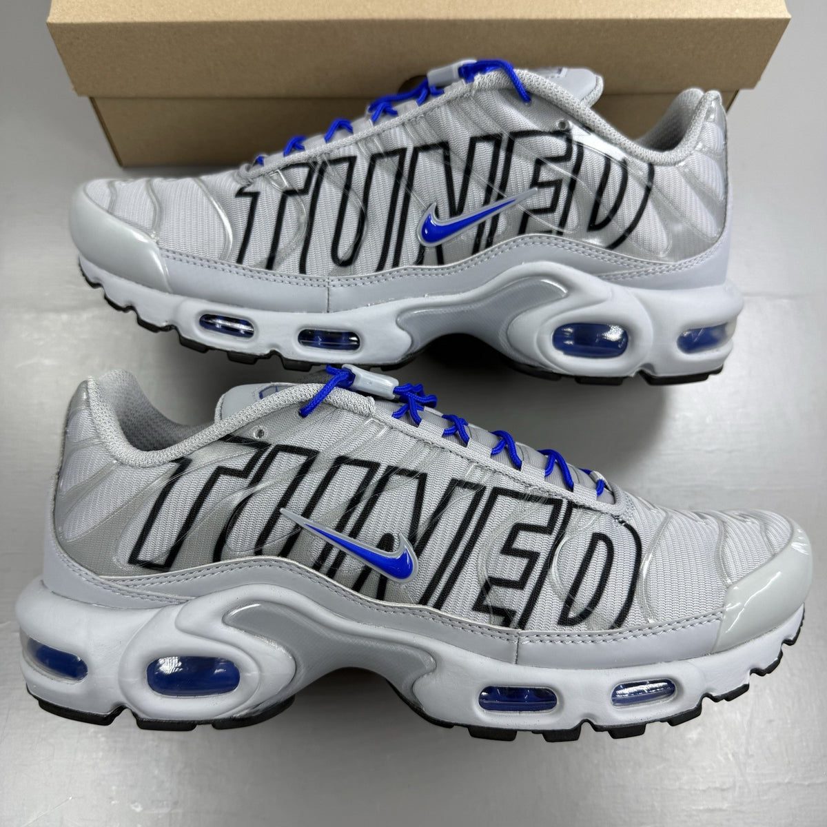 Nike Air Max Plus TN trainers grey with racer blue accents and unique design details.