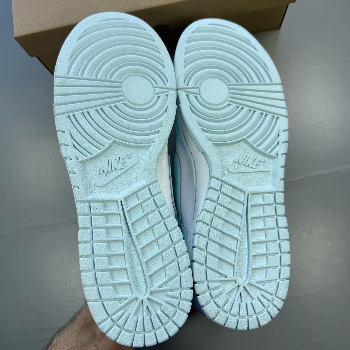 Nike Dunk Low trainers glacier blue and white with signature swoosh logo.