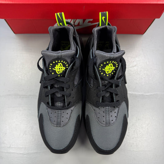 Nike black trainers with volt accents and dark grey detailing, featuring iconic Huarache design.