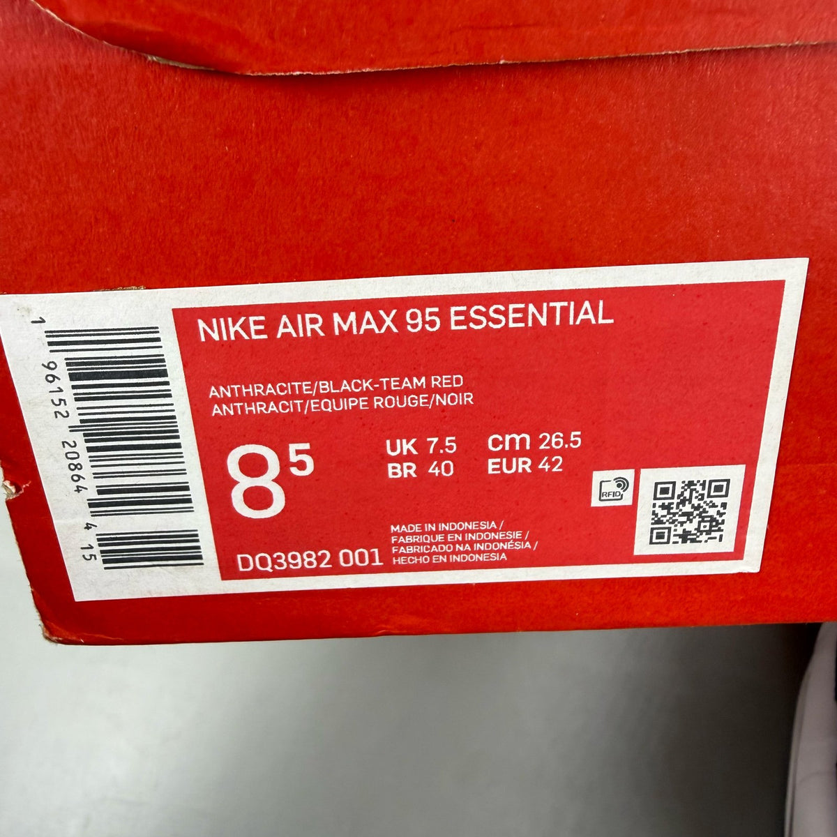 Nike black trainers with red accents and grey detailing, featuring iconic Air Max design.
