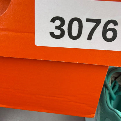 Nike white trainers with bleached turquoise accents and logo detail.