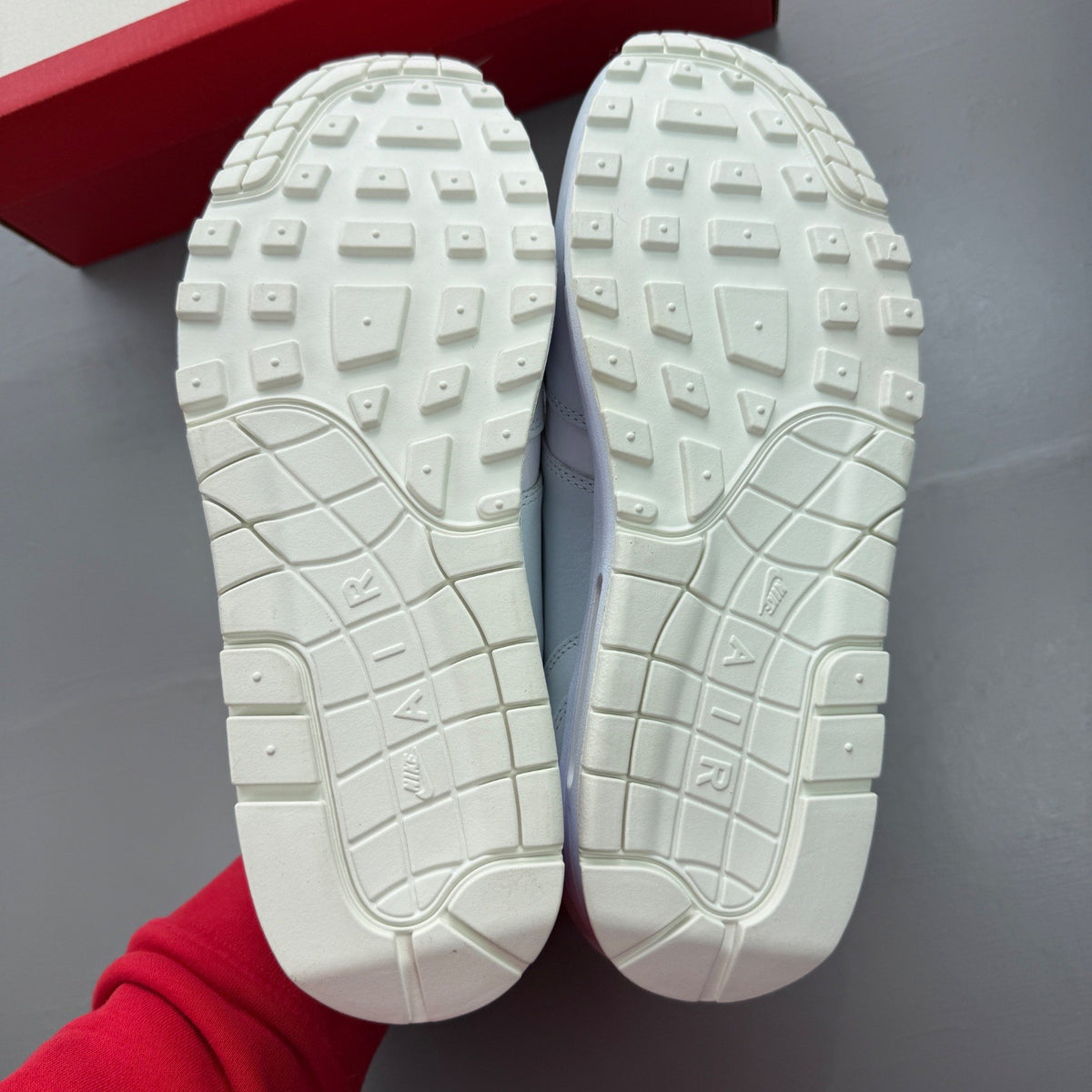 Nike Air Max 1 white trainers with rubberized details and classic logo design.