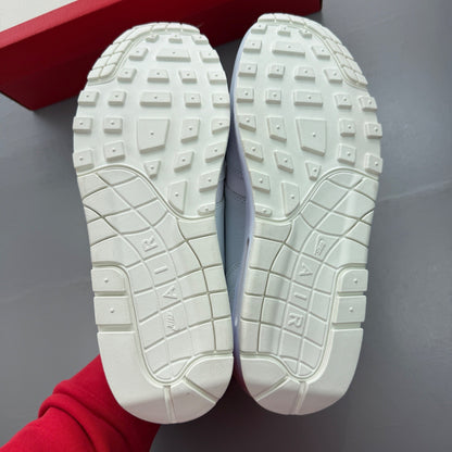 Nike Air Max 1 white trainers with rubberized details and classic logo design.