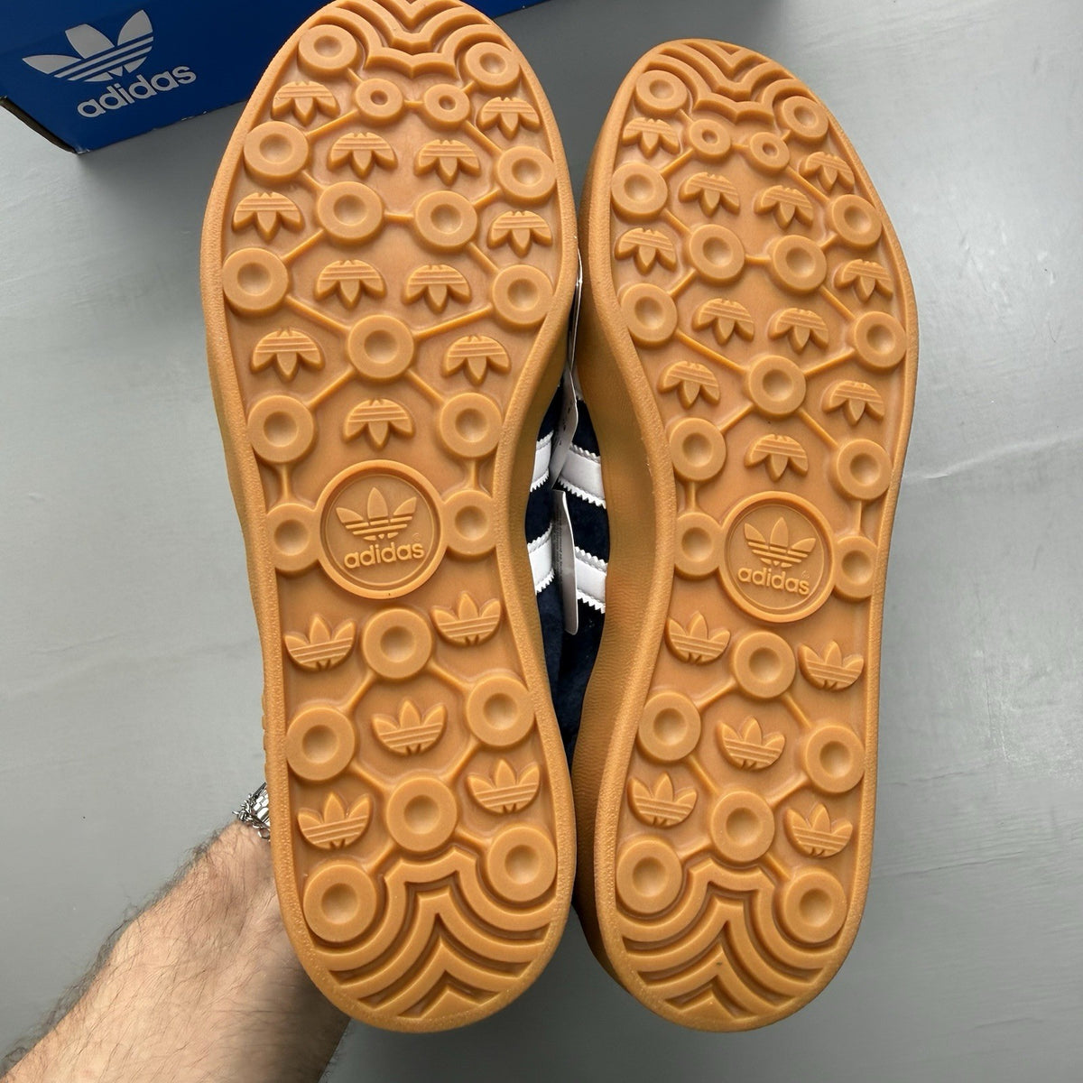 Adidas blue trainers with white and gum sole, featuring gold accents and logo.