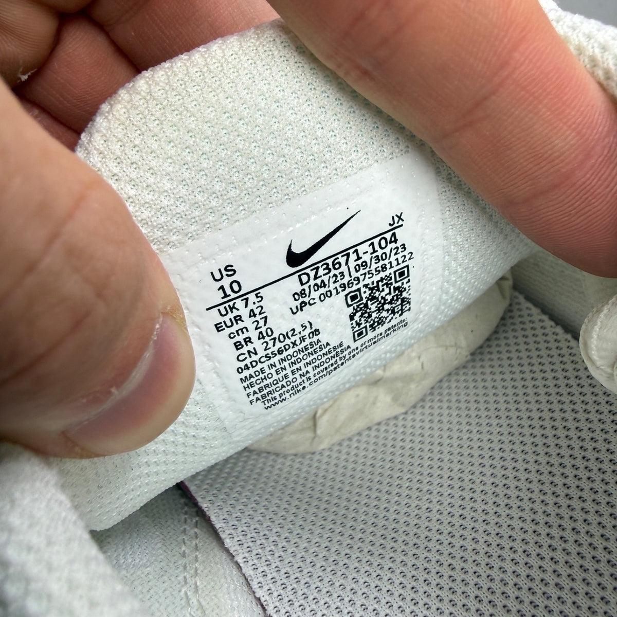 Nike white athletic shoes with Air Max Plus TN design and visible logo details.