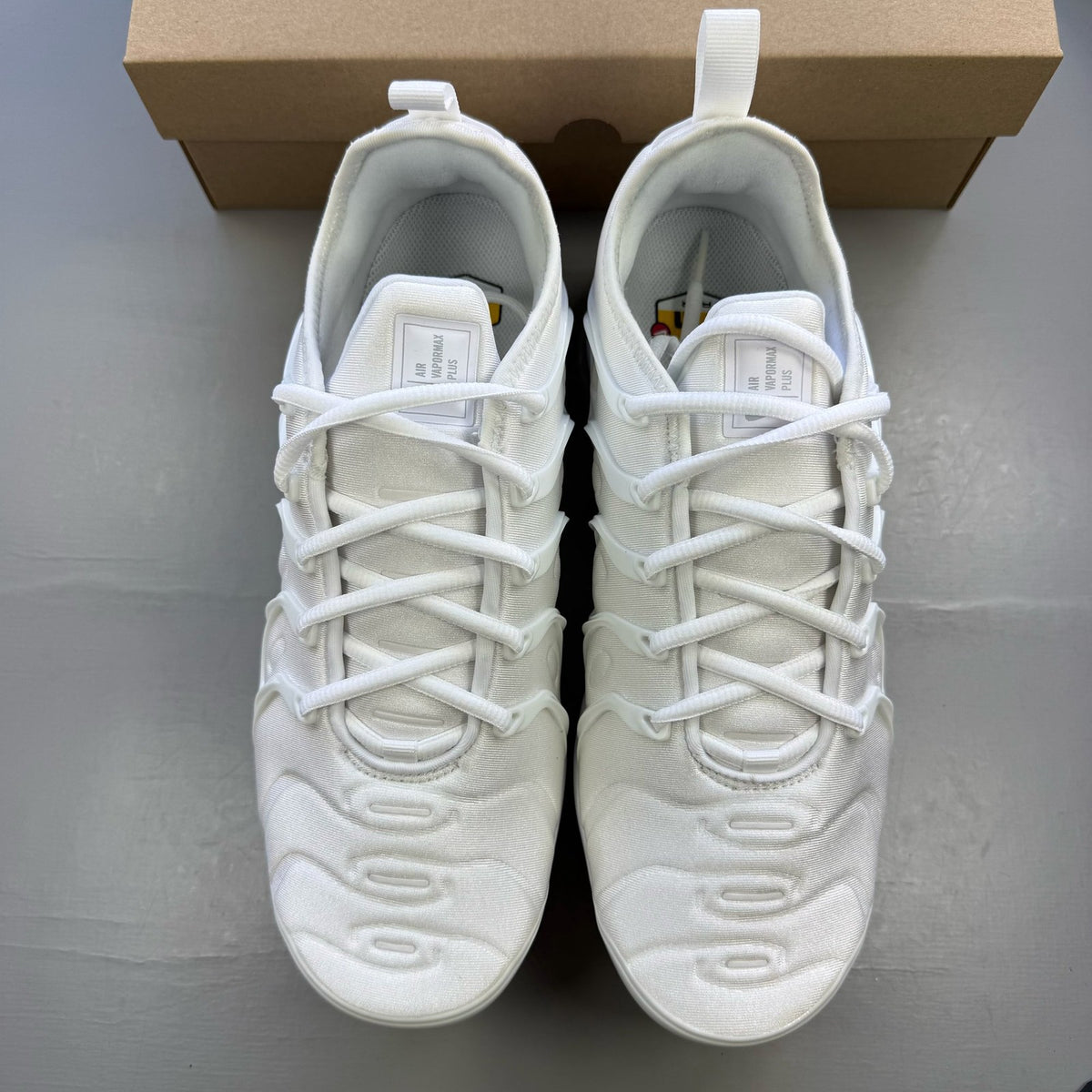 Nike white trainers with Pure Platinum accents and signature logo detailing.