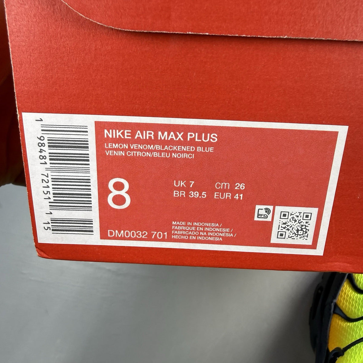 Nike Air Max Plus TN yellow trainers with orange accents and signature swoosh logo.