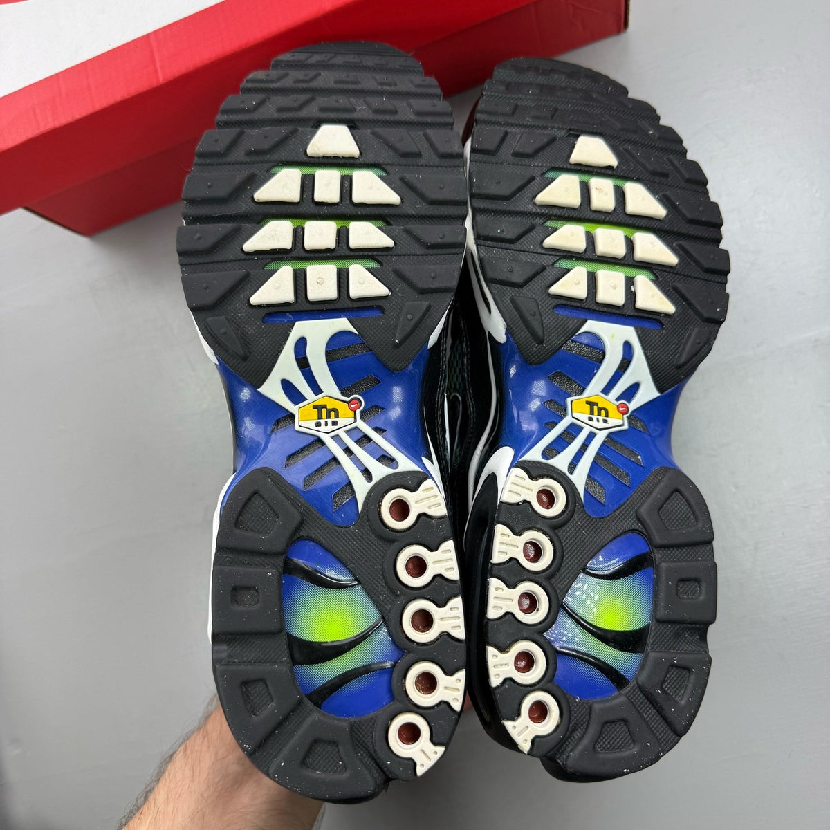 Nike Air Max Plus TN green trainers with black and volt accents, featuring signature logo.
