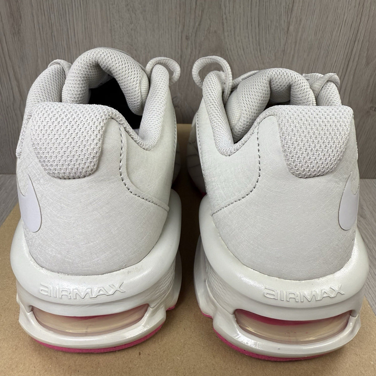 Nike Air Max trainers beige with pink accents and logo detail on the side.