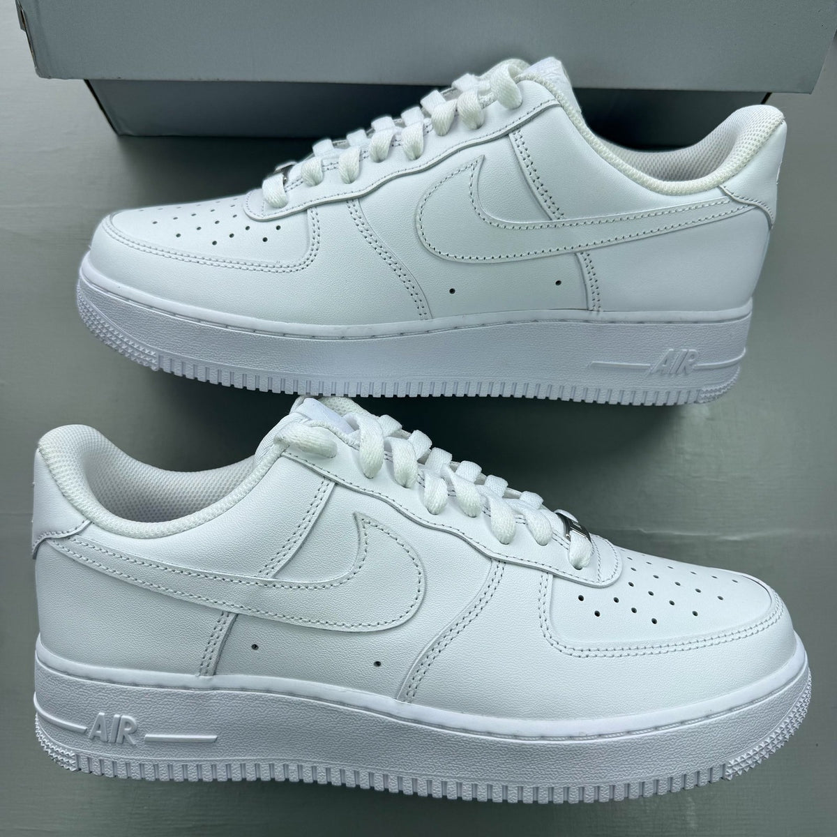 Nike Air Force 1 '07 white trainers with classic silhouette and embossed logo.