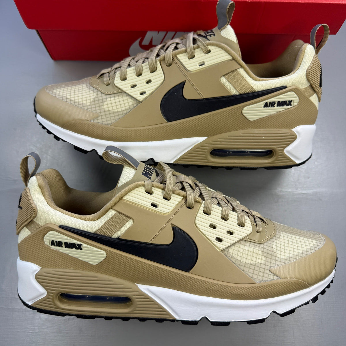 Nike Air Max 90 beige sneakers with black accents and khaki details.