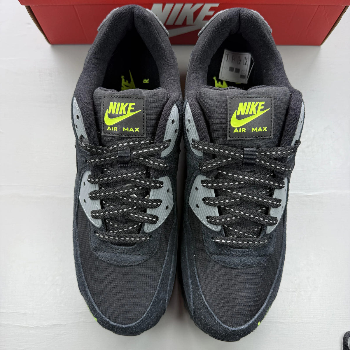 Nike Air Max 90 black trainers with volt and cool grey swoosh logo.