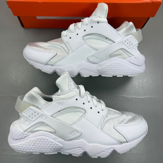 Nike Air Huarache white trainers with mesh upper and signature logo detailing.