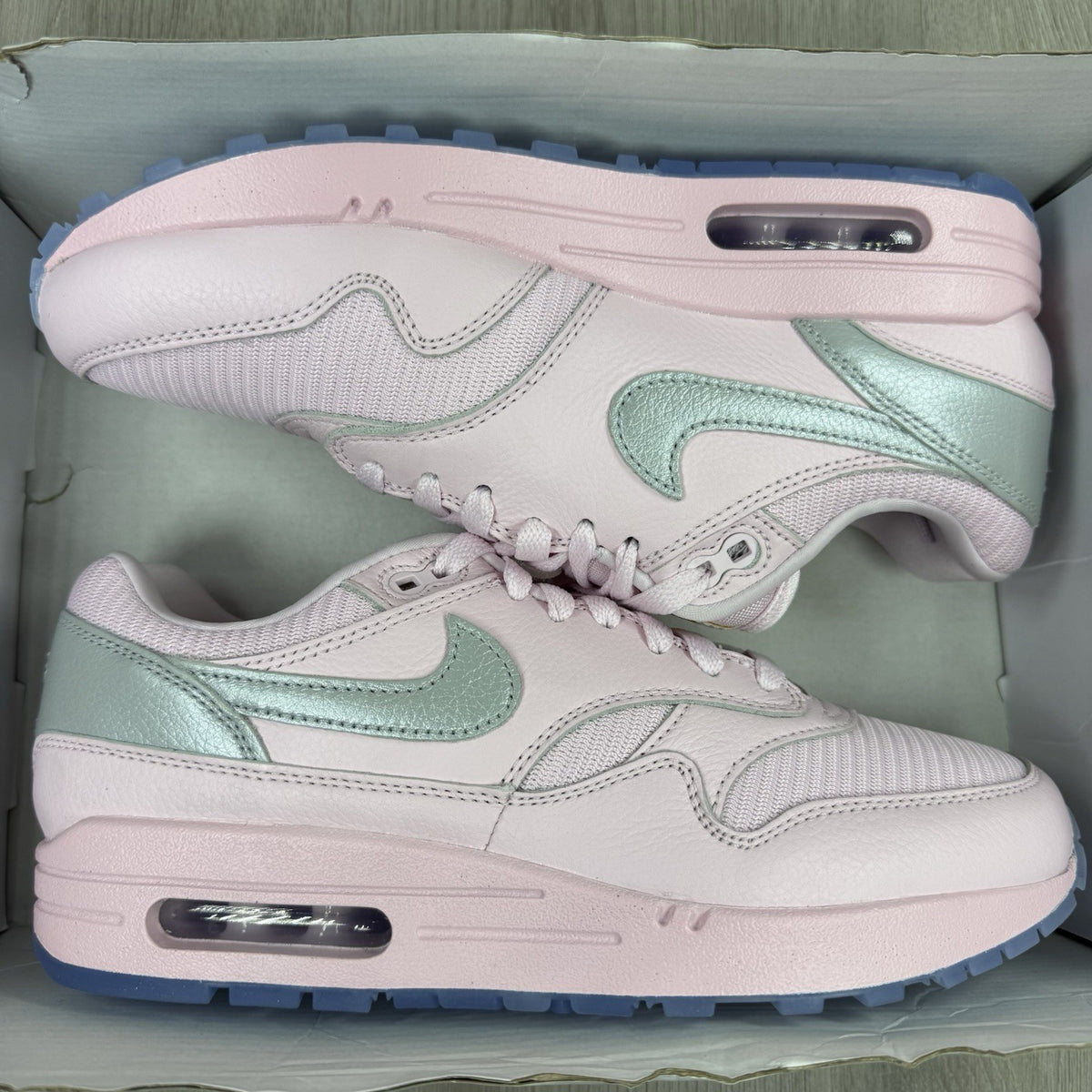 Nike Air Max 1 trainers pink with silver accents and unique design details.