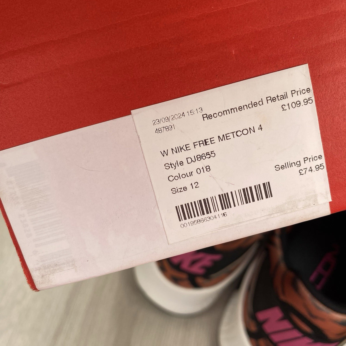 Nike Free Metcon 4 trainers black with tiger burnt sunrise accents and logo detail.
