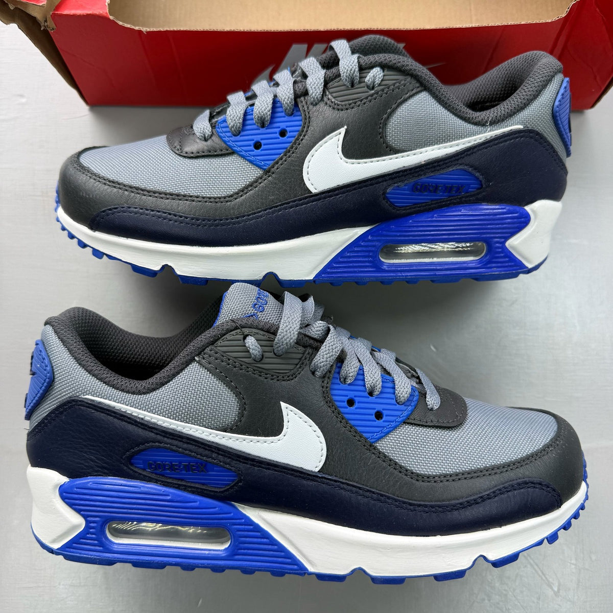 Nike Air Max 90 grey sneakers with Gore-Tex material and blue accents.