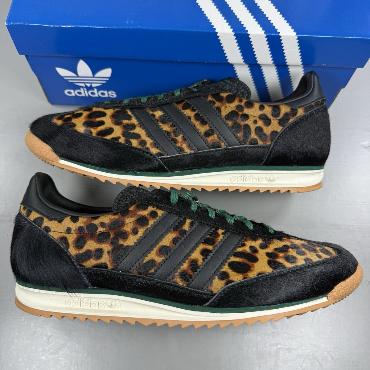 Adidas black trainers with leopard print accents and classic three-stripe logo.
