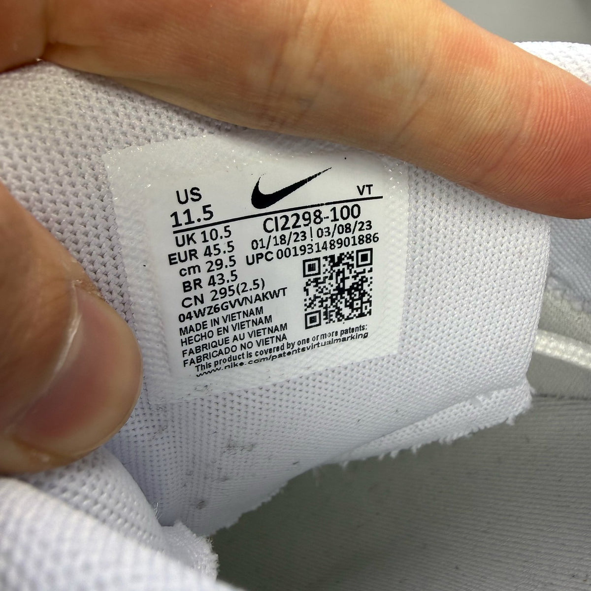 Nike Air Max 95 white trainers with grey accents and distinctive air cushioning design.