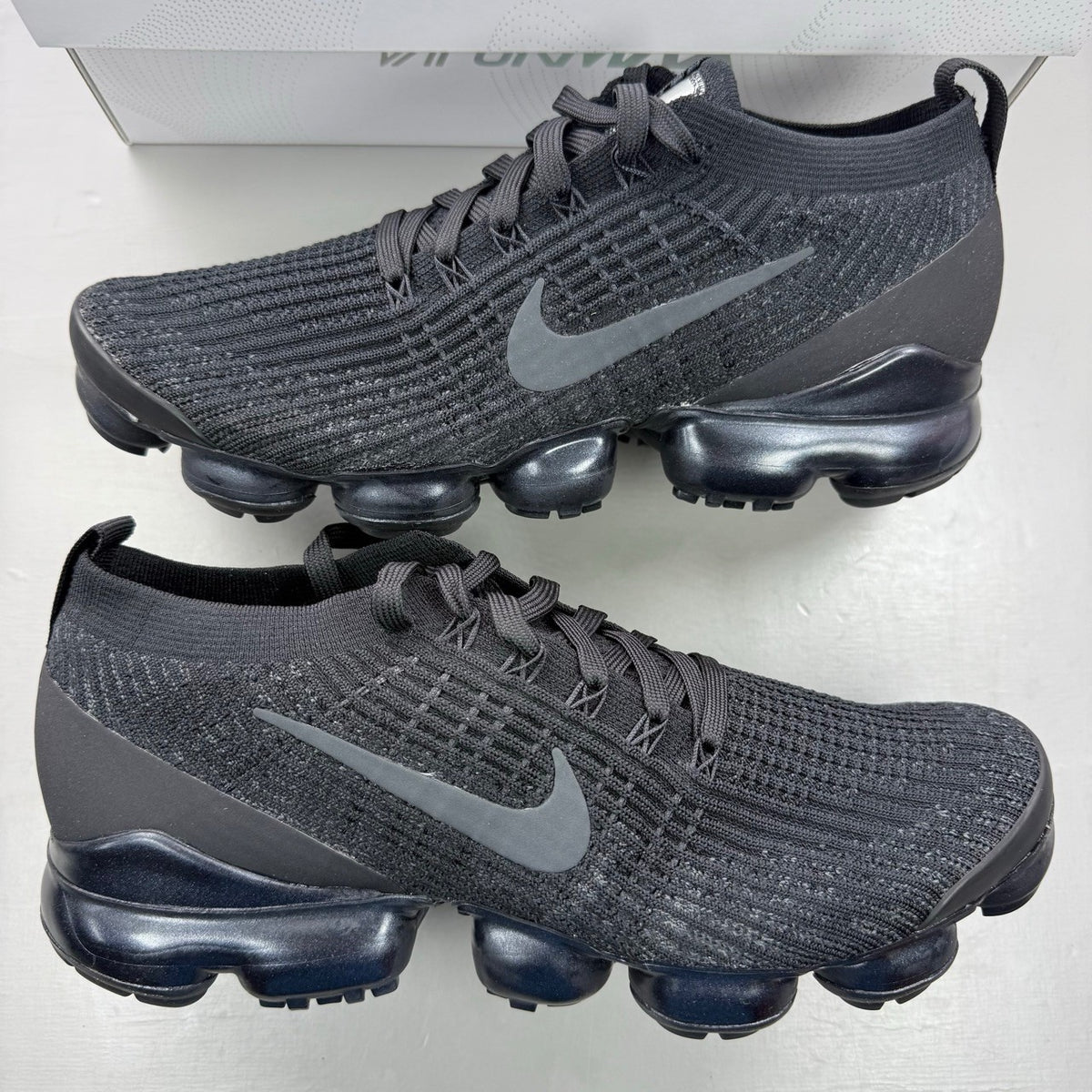 Nike Air VaporMax Flyknit 3 black sneakers with distinctive air cushioning and sleek design.