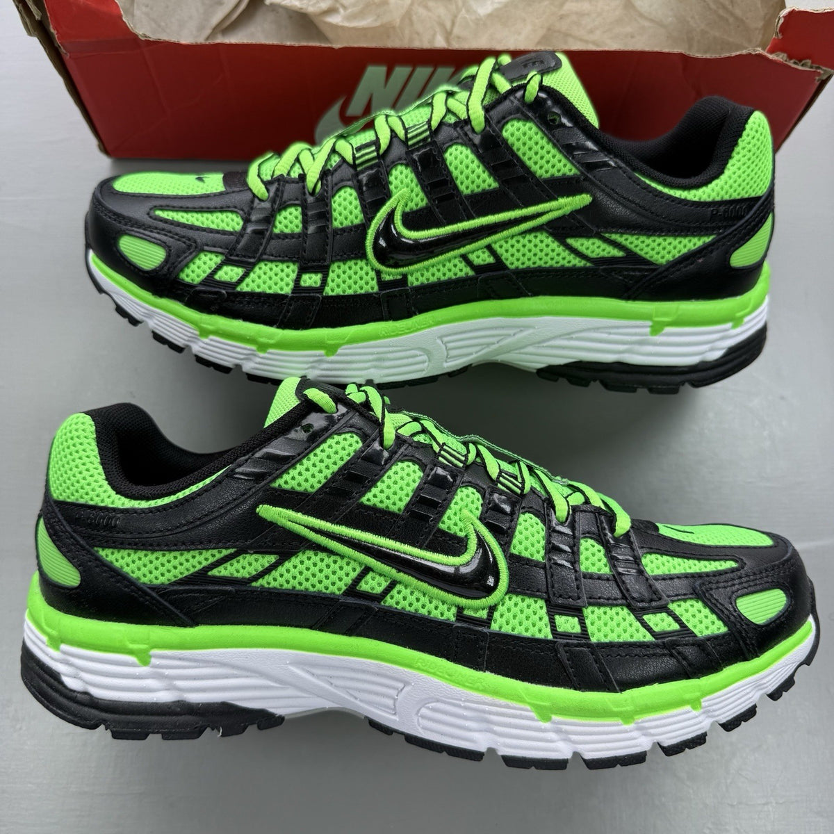 Nike P-6000 trainers black with green and white accents, mesh and synthetic material.
