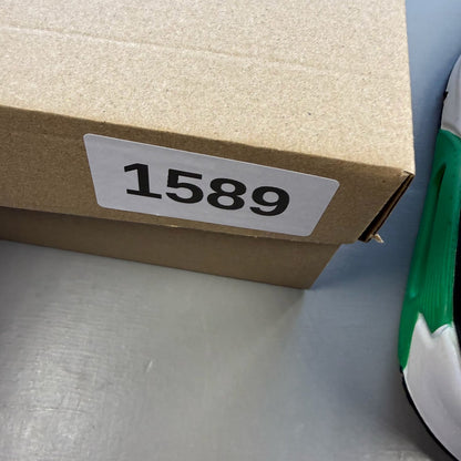 Nike Air Max 90 black trainers with green accents and white sole, featuring logo details.