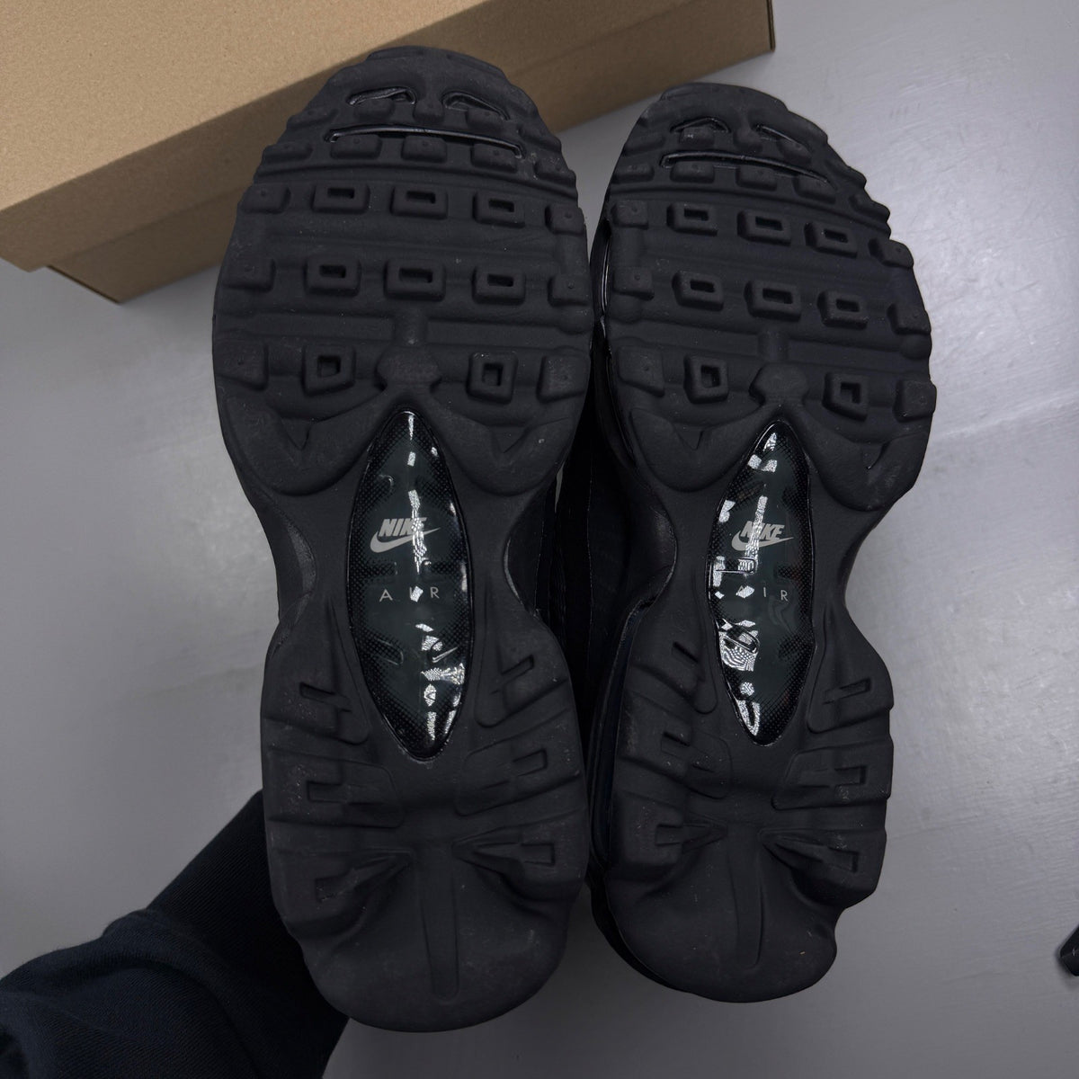 Nike Air Max 95 black trainers with cool grey accents and signature logo details.