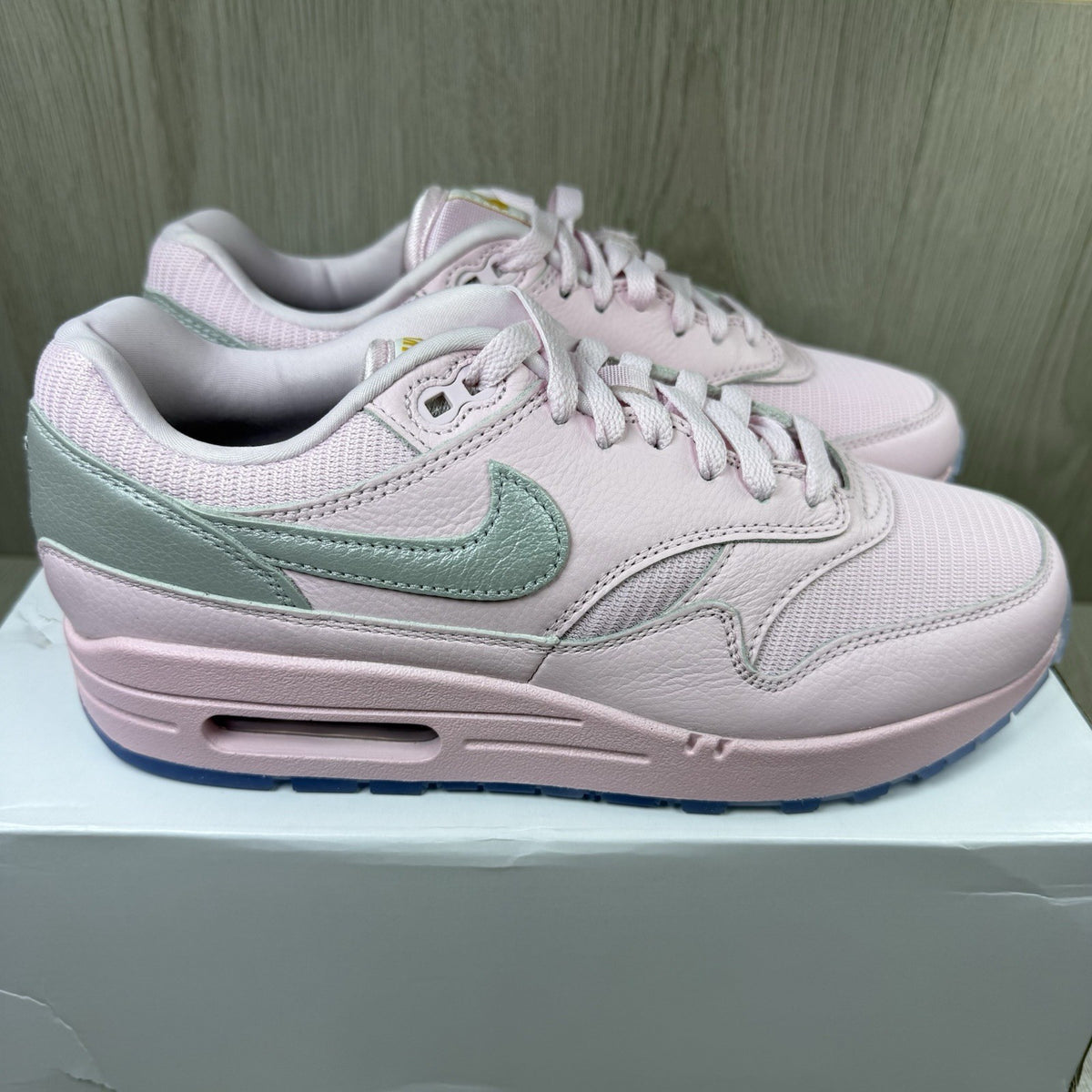 Nike Air Max 1 trainers pink with silver accents and unique design details.