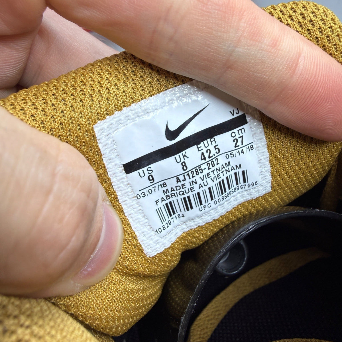 Nike black trainers with muted bronze accents and Air Max cushioning design.
