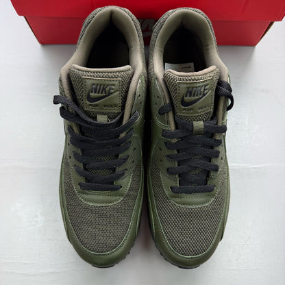 Nike Air Max 90 green trainers with black accents and logo detail.