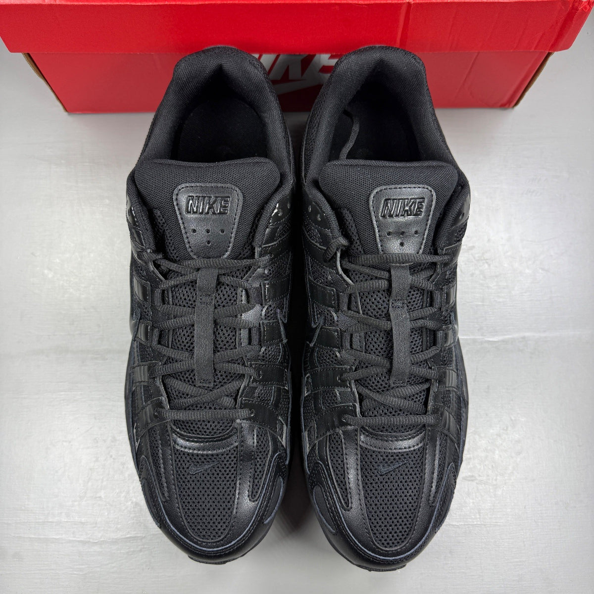 Nike black trainers with mesh upper, reflective detailing, and padded collar.
