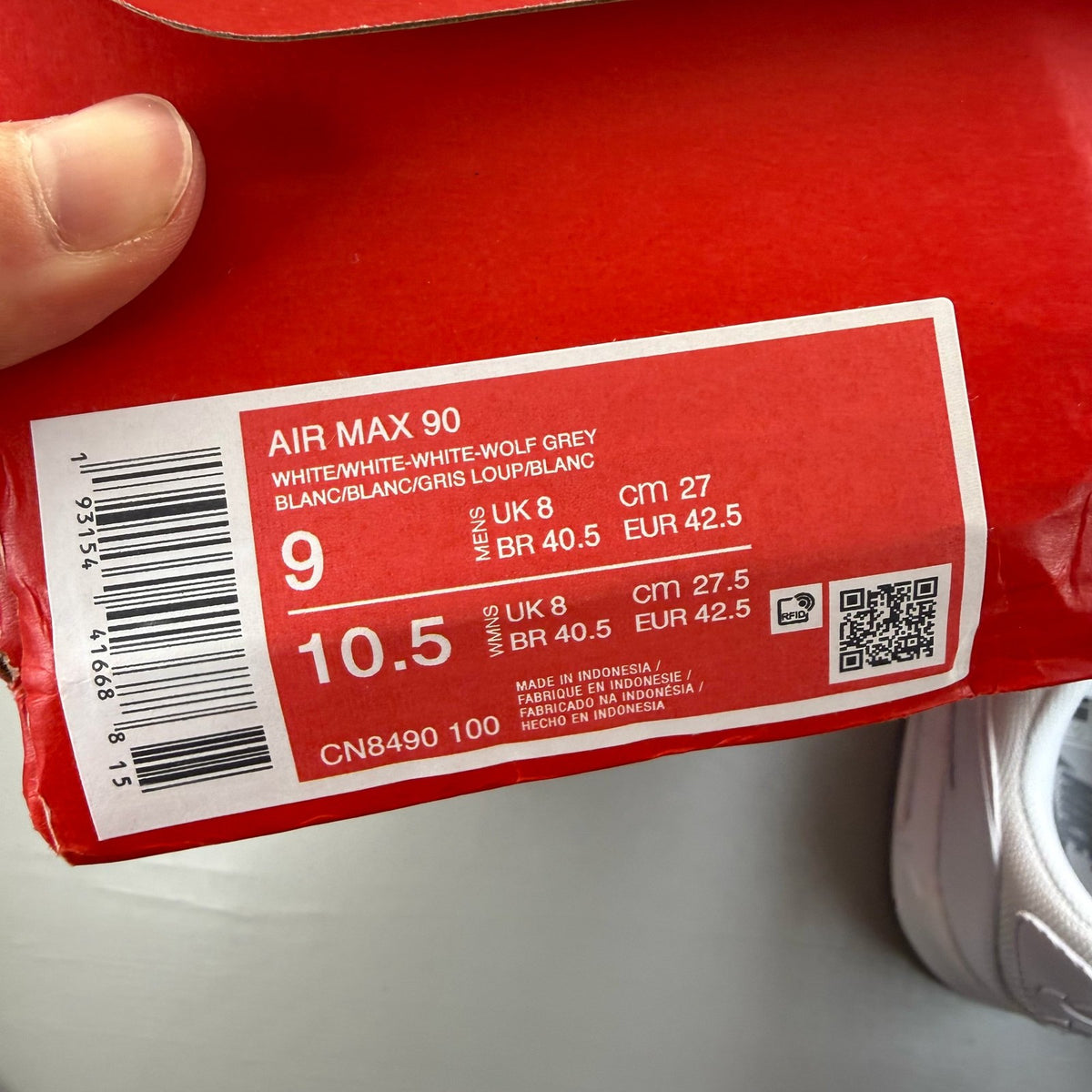 Nike Air Max 90 white trainers with iconic swoosh logo and breathable mesh material.