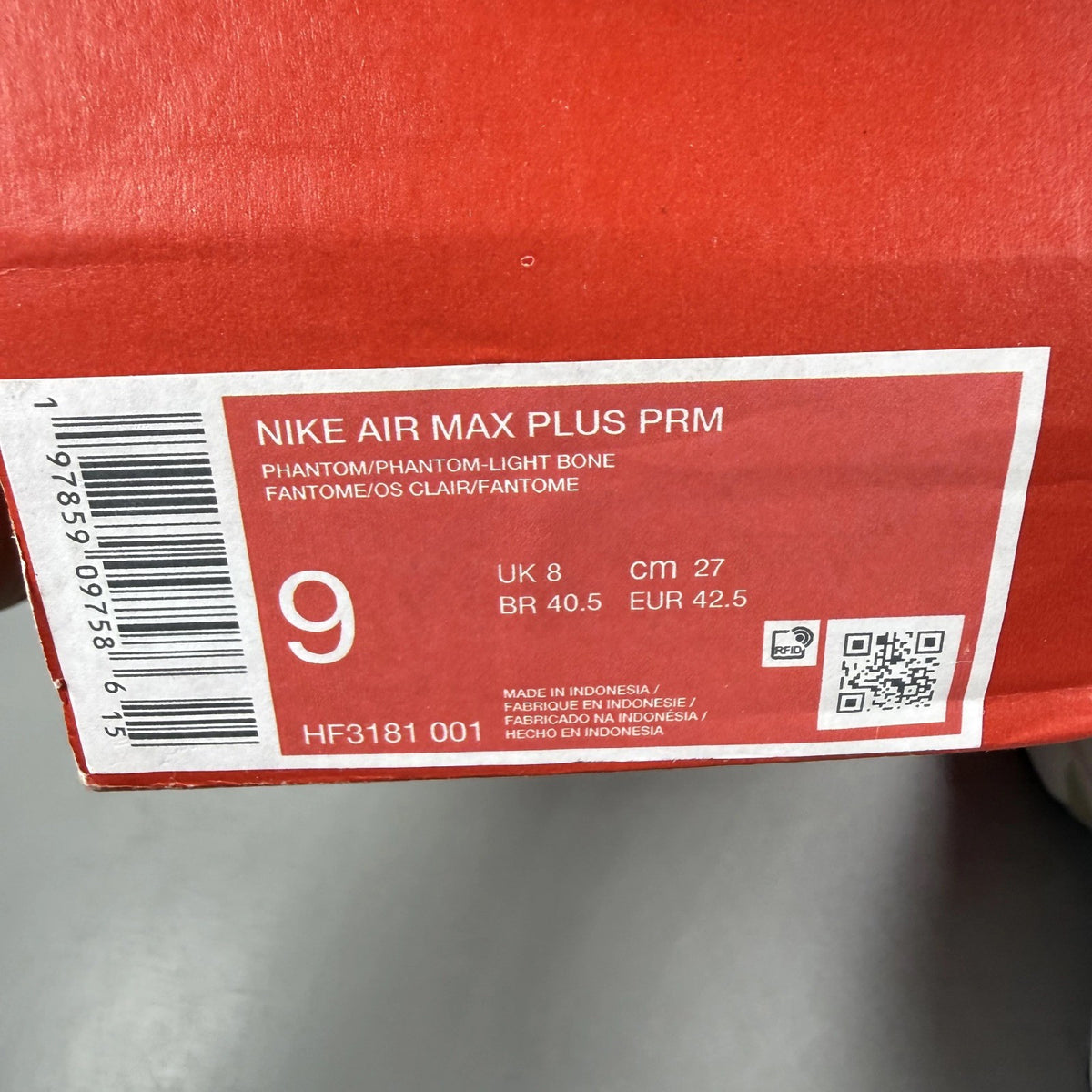 Nike Air Max Plus trainers white with burgundy accents and signature logo details.