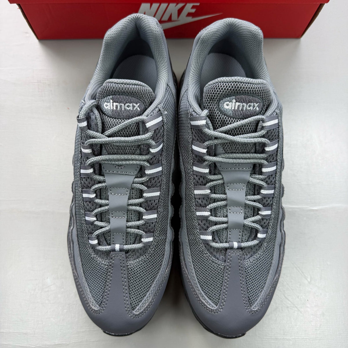 Nike Air Max 95 grey trainers with distinctive design and logo details.