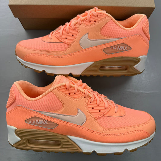 Nike Air Max 90 orange trainers with white and gum sole, featuring iconic logo.