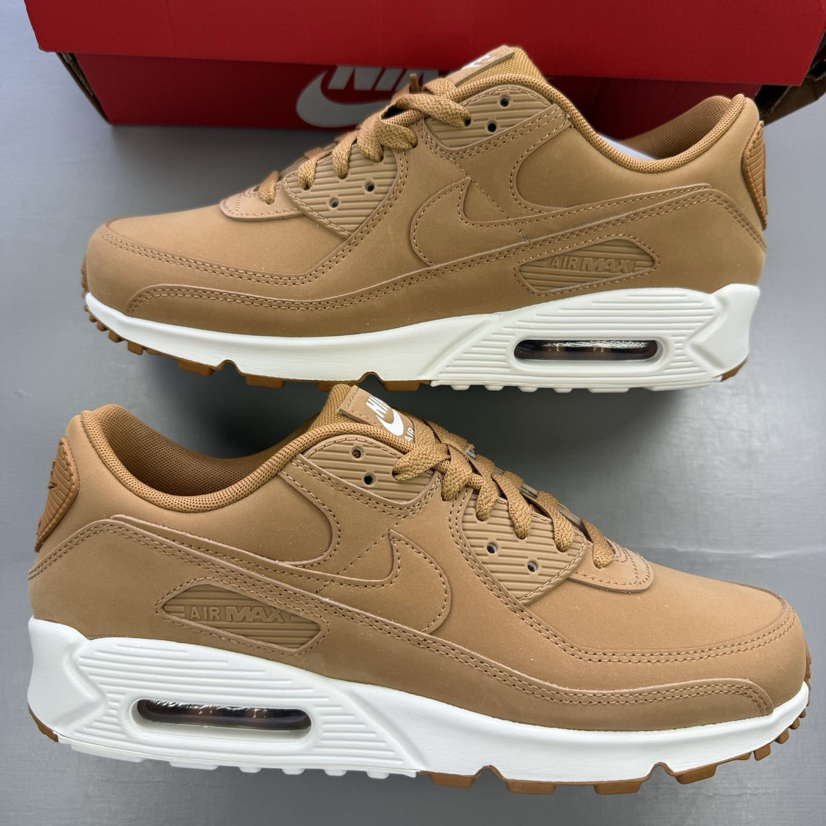 Nike Air Max 90 Premium beige trainers with white accents and textured suede material.