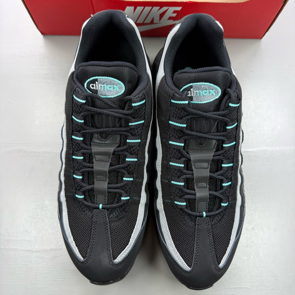 Nike Air Max 95 black trainers with Aurora Green and Grey accents, featuring iconic logo.
