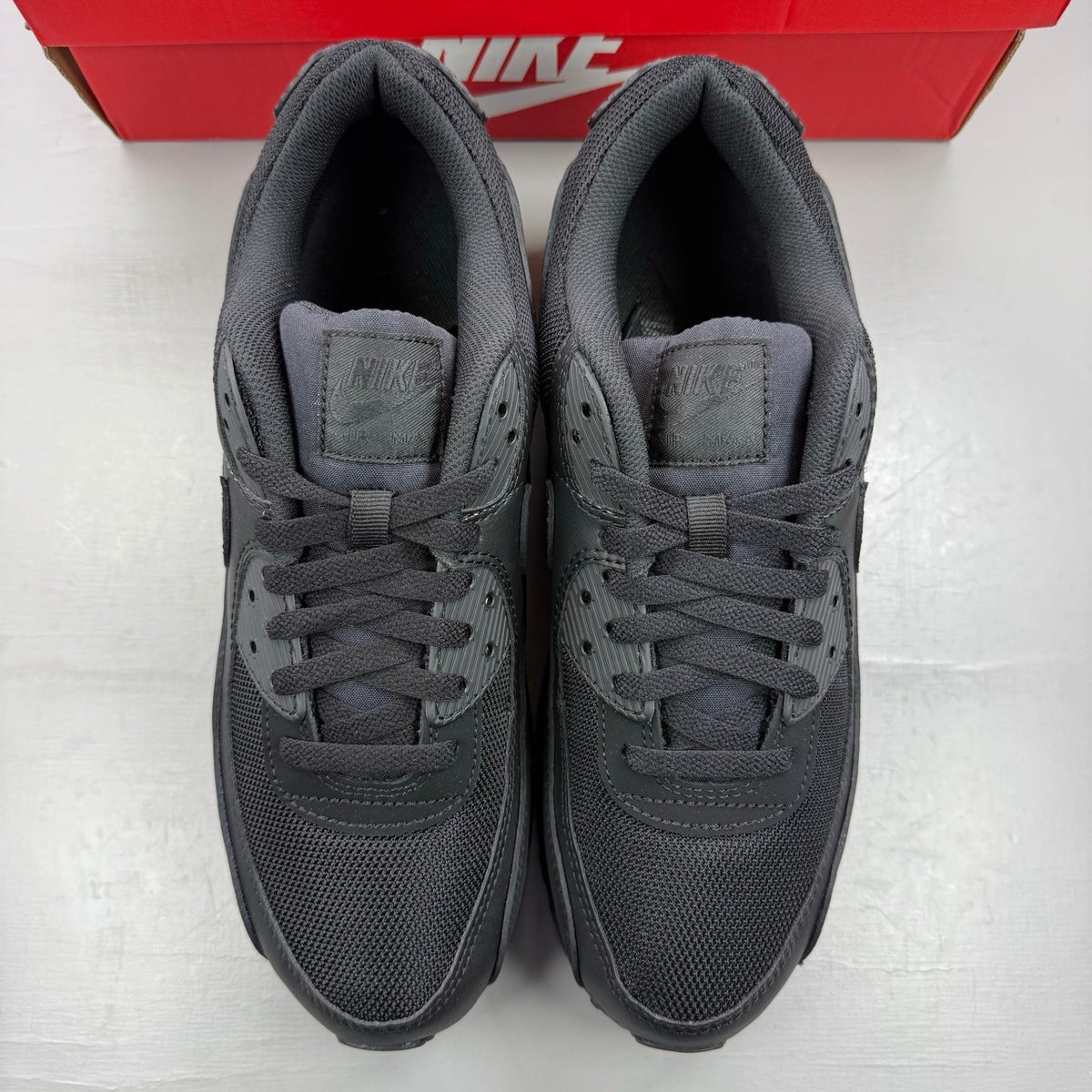 Nike black deck shoes with Air Max cushioning and sleek design.