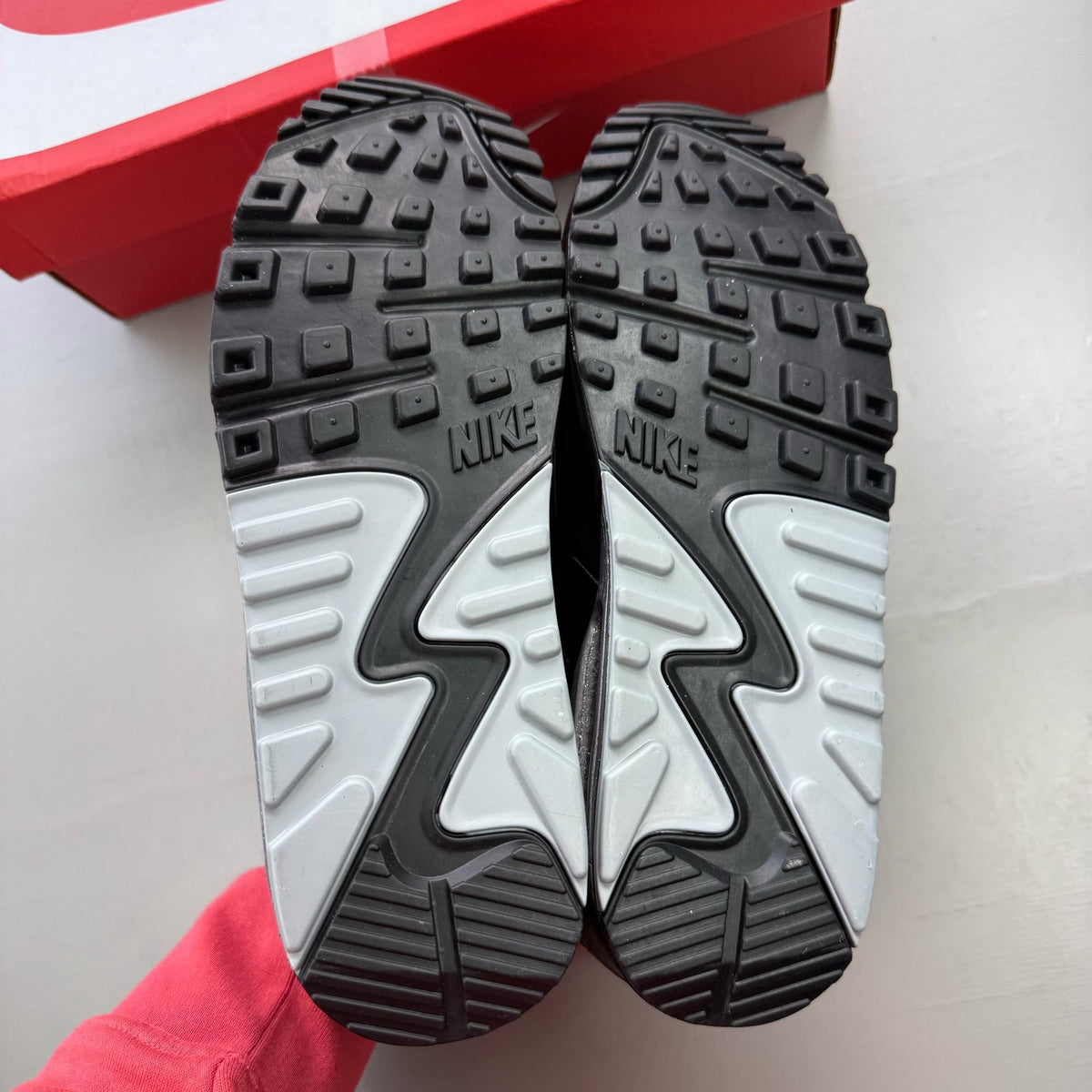 Nike black trainers with metallic silver swoosh logo and sleek design.