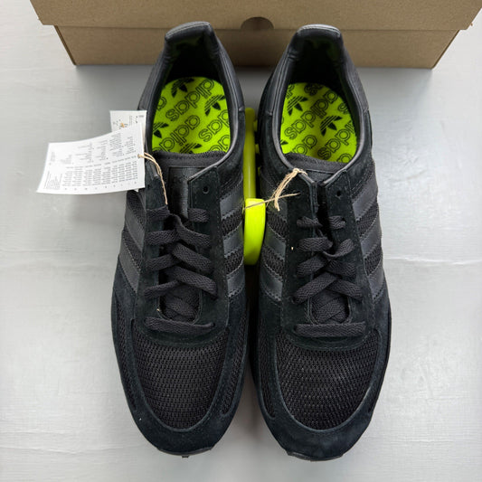 Adidas black trainers with yellow accents and classic three-stripe logo design.