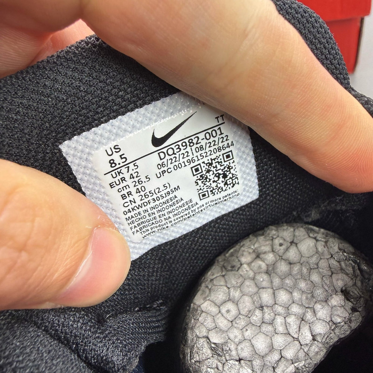 Nike black trainers with red accents and grey detailing, featuring iconic Air Max design.