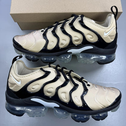 Nike beige trainers with black accents and Air cushioning design.