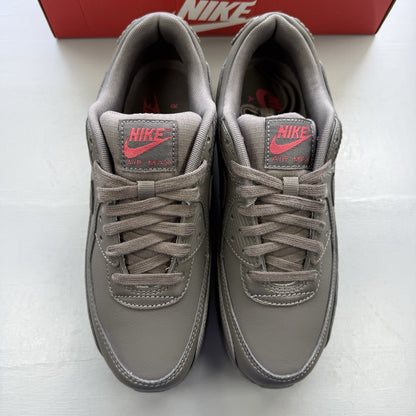 Nike Air Max 90 trainers grey with red accents and logo detail.