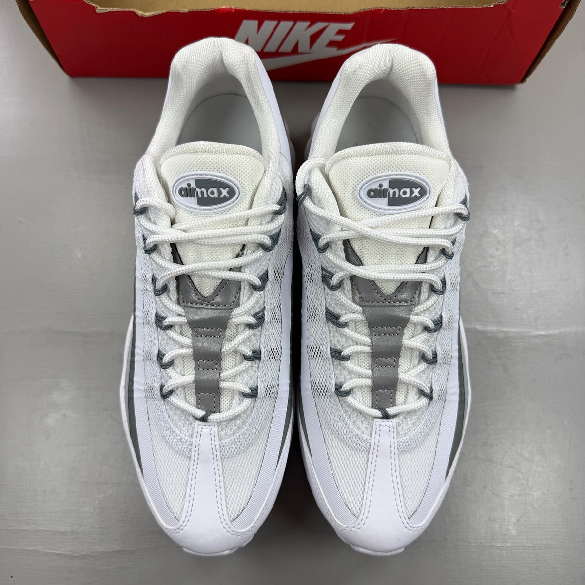 Nike Air Max 95 Ultra white trainers with grey accents and signature logo details.