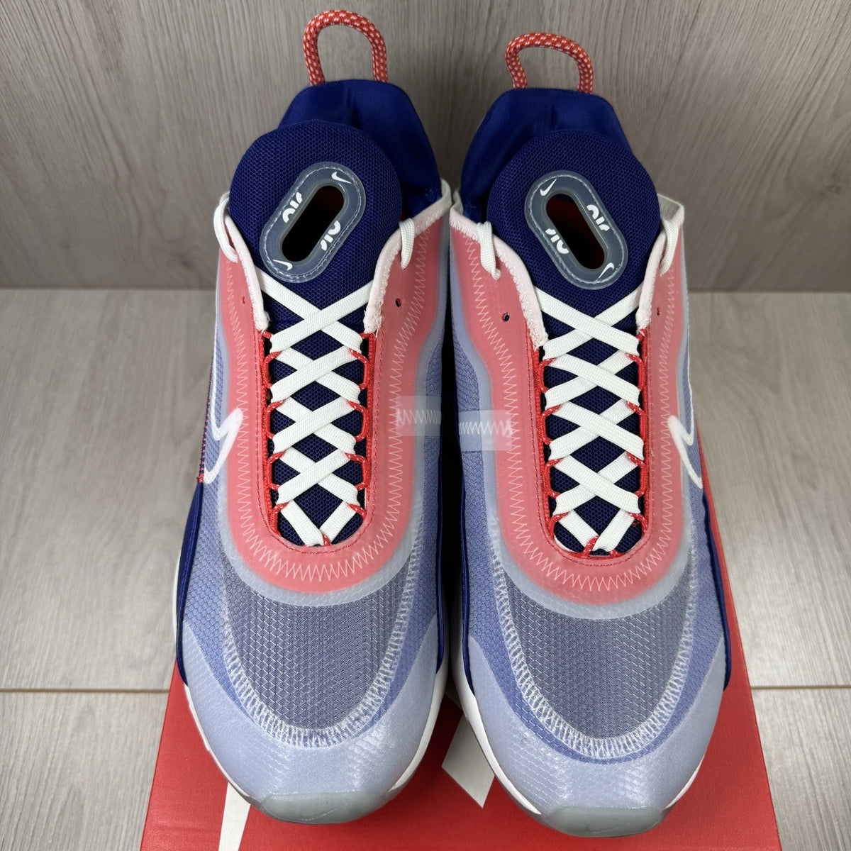 Nike Air Max 2090 trainers white with red and blue accents, featuring logo details.