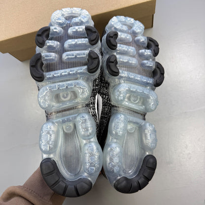 Nike athletic shoes black Flyknit design with white accents and VaporMax sole.